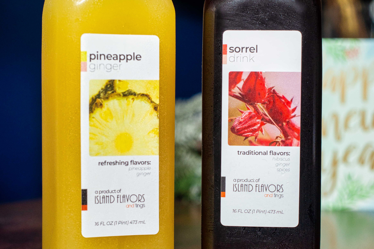 Two bottles labeled "Pineapple Ginger Drink" and "Sorrel Drink" from island flavors, displayed with a focus on their vibrant labels and ingredients.